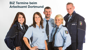 Gruppe von Bediensteten steht zusammen. Aufschrift im Bild: 